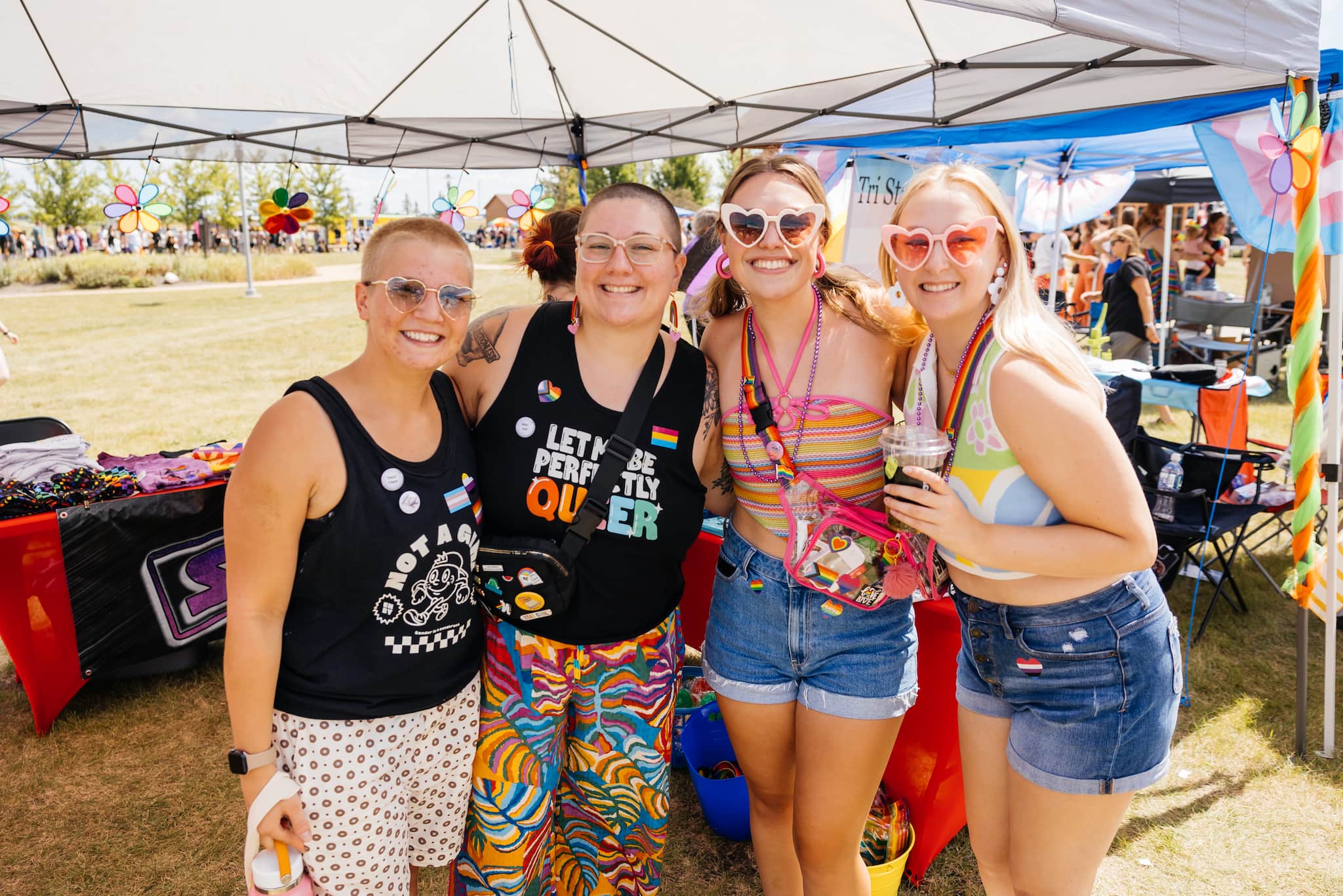 Attendees joyfully pose at a colorful pride event, celebrating love and unity within the vibrant pride community.