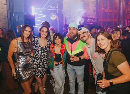 Lively pride event featuring a group of people under vibrant neon lights