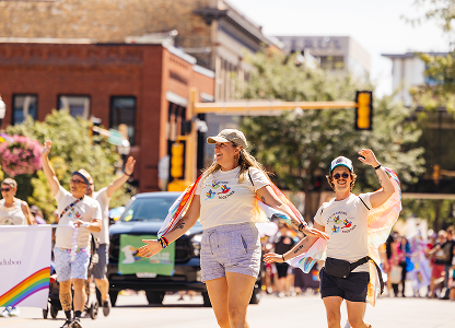 Man and woman holding a rainbow flag during a pride event, celebrating diversity at a pride parade