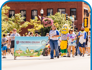 Volunteers of different community groups during a pride parade, celebrating inclusion in the community.