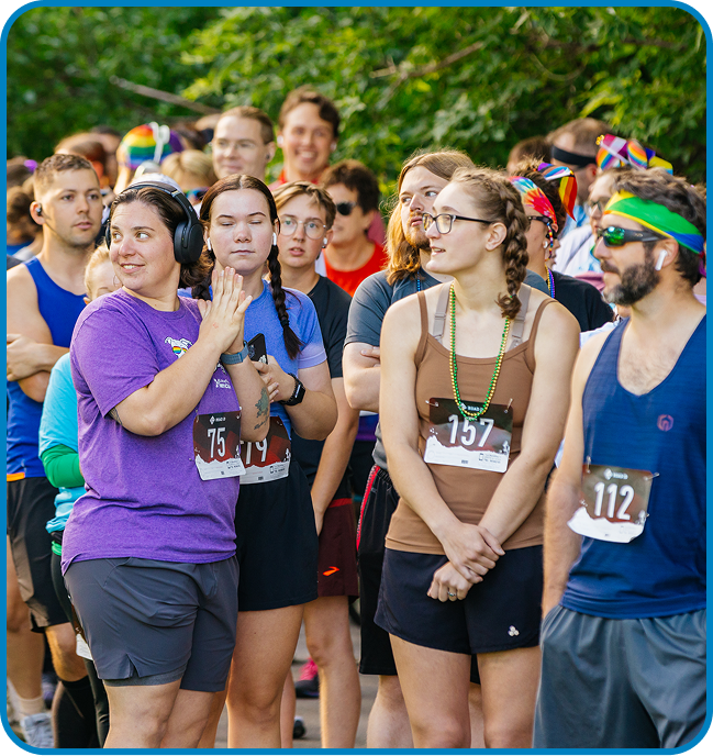 Diverse individuals at a vibrant pride event, showcasing joy and community spirit during a fun run.
