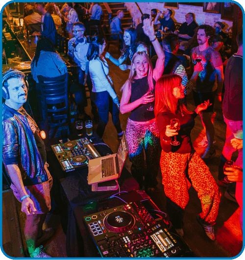 Colorful pride event featuring a lively group of people dancing under disco lights, celebrating diversity