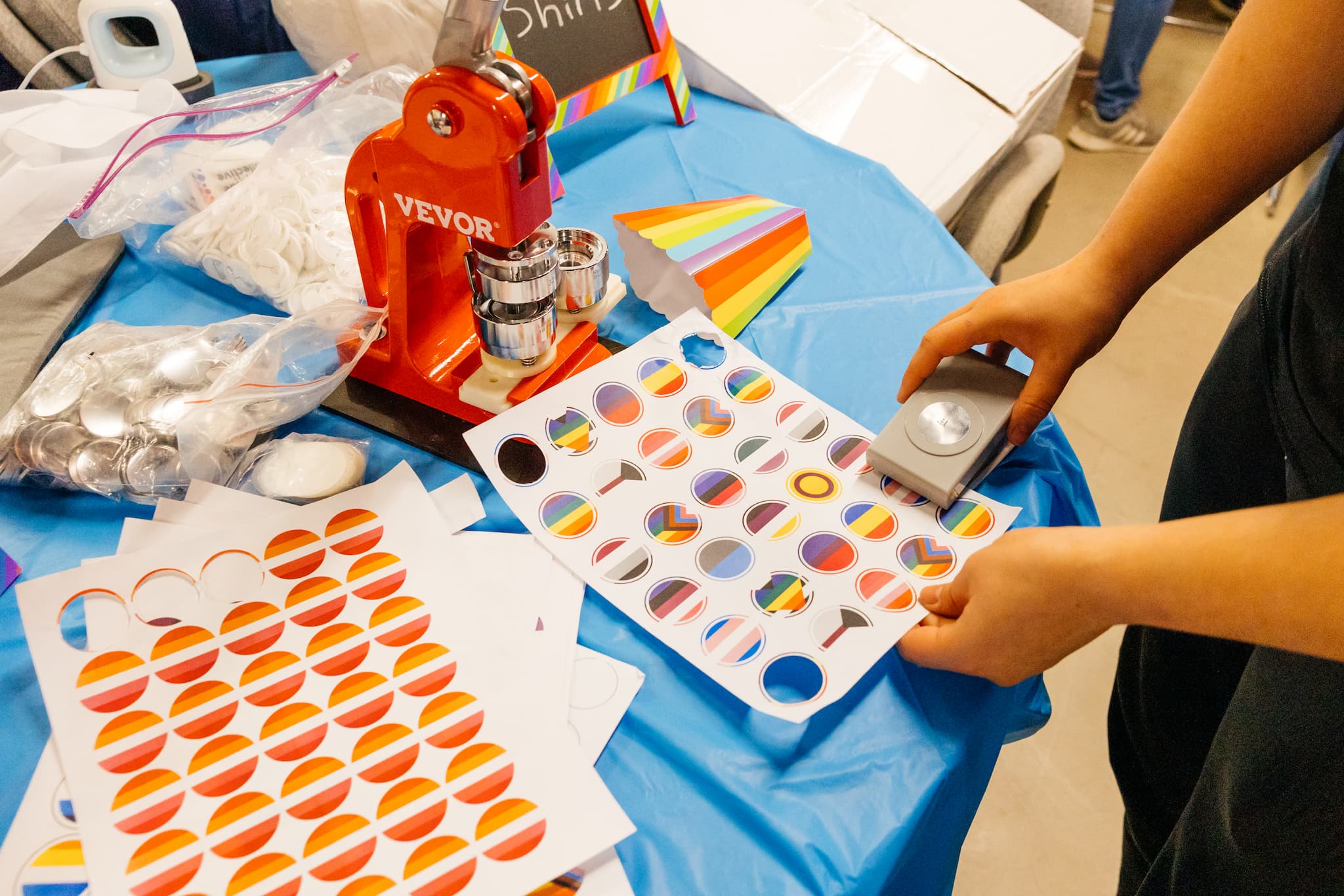 Person holding stickers featuring multiple pride flags during a lively pride event.