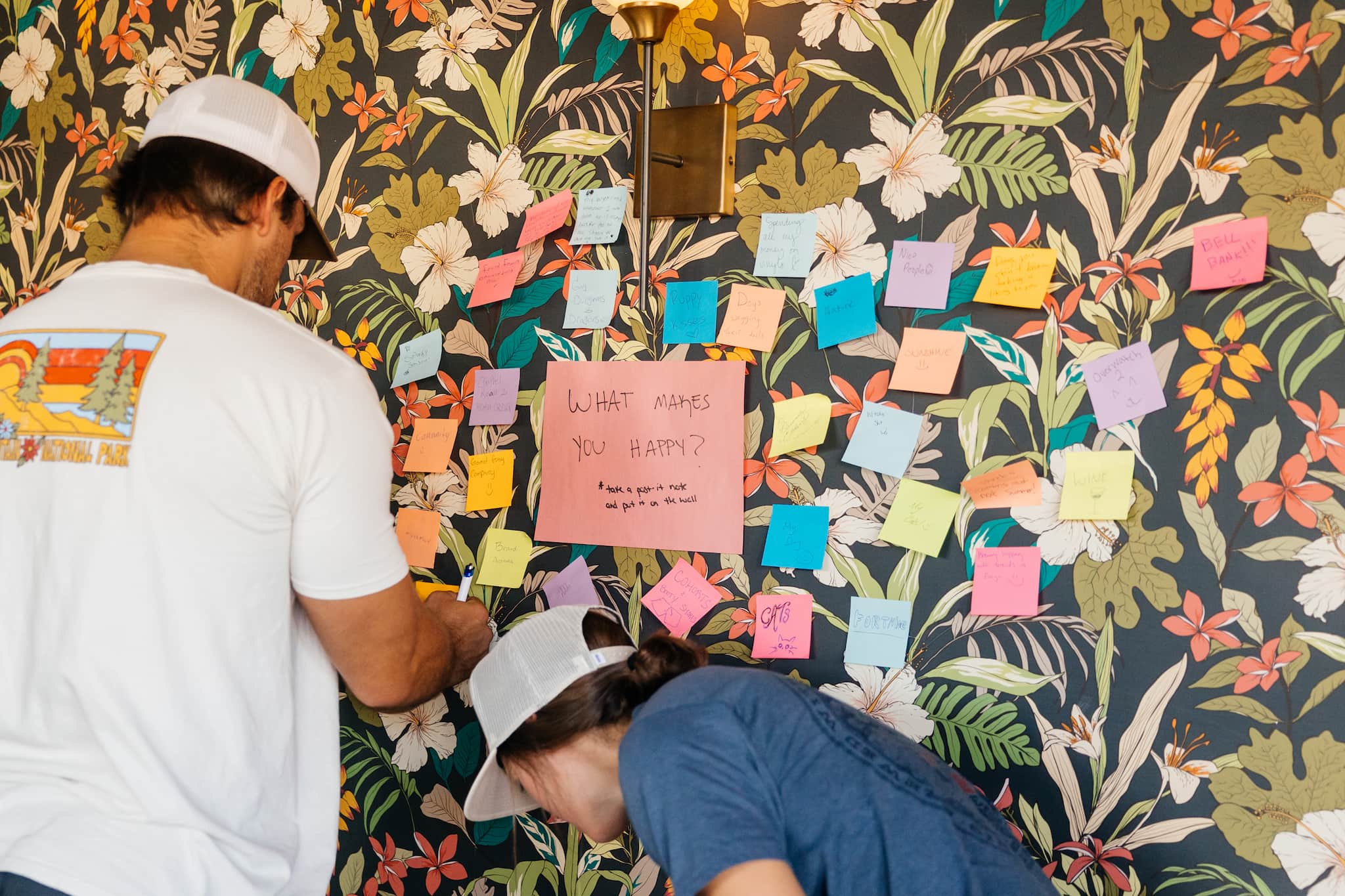 Attendees posting on a colorful wall of sticky notes, celebrating diversity at a pride event