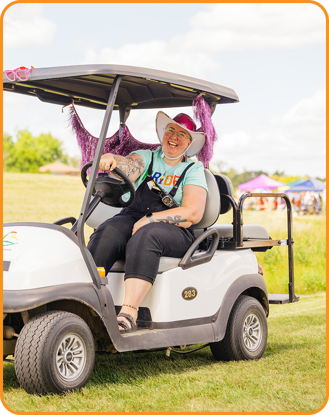 Woman in a golf cart, getting involved in a lively pride event